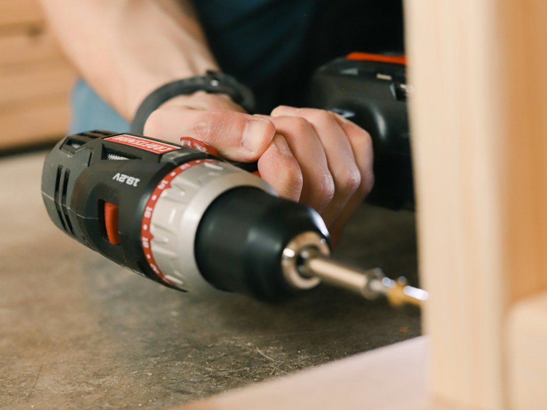 Furniture being assembled with a cordless drill